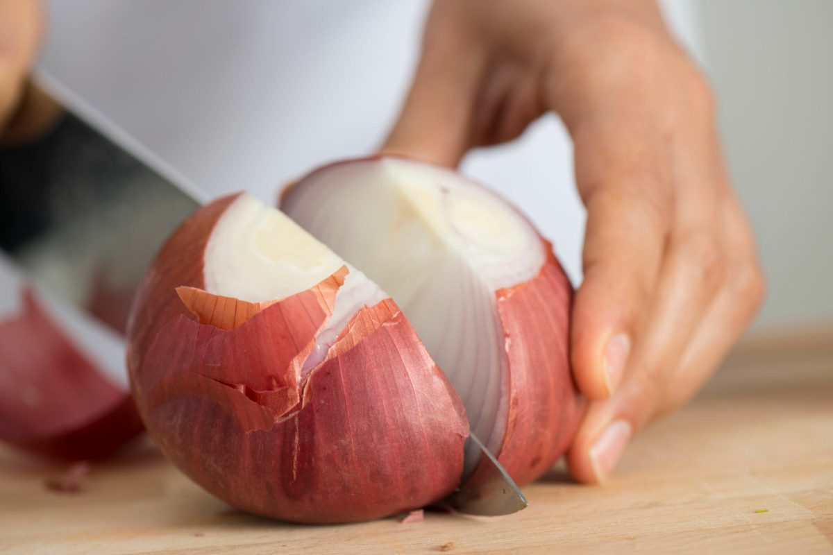 Woman chopping onion close up.
